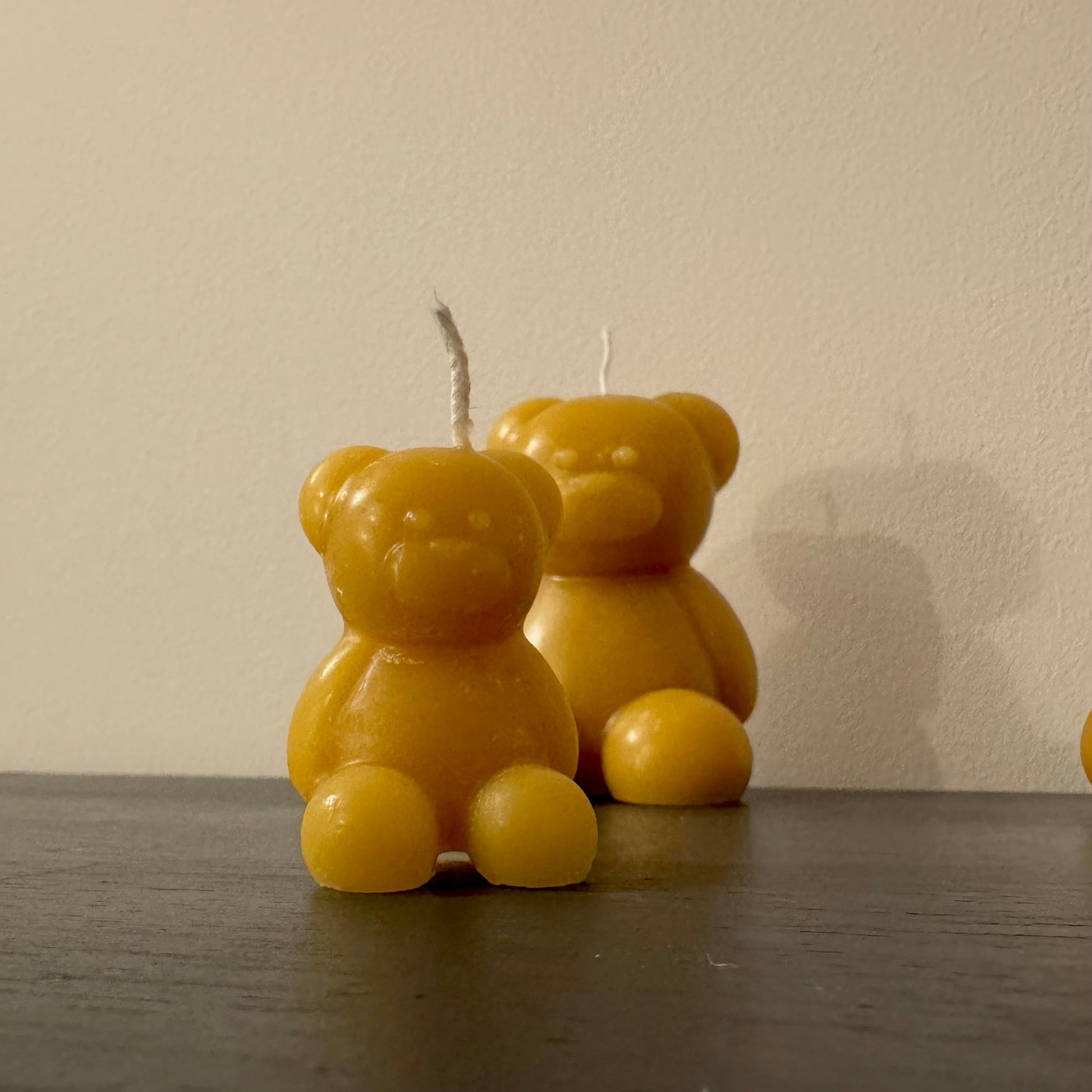 A pair of beeswax bears sit against a white background, they create a cosy and cute eco friendly present idea for new parents